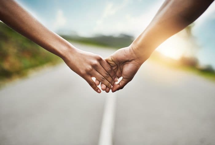 Two hands holding across a road
